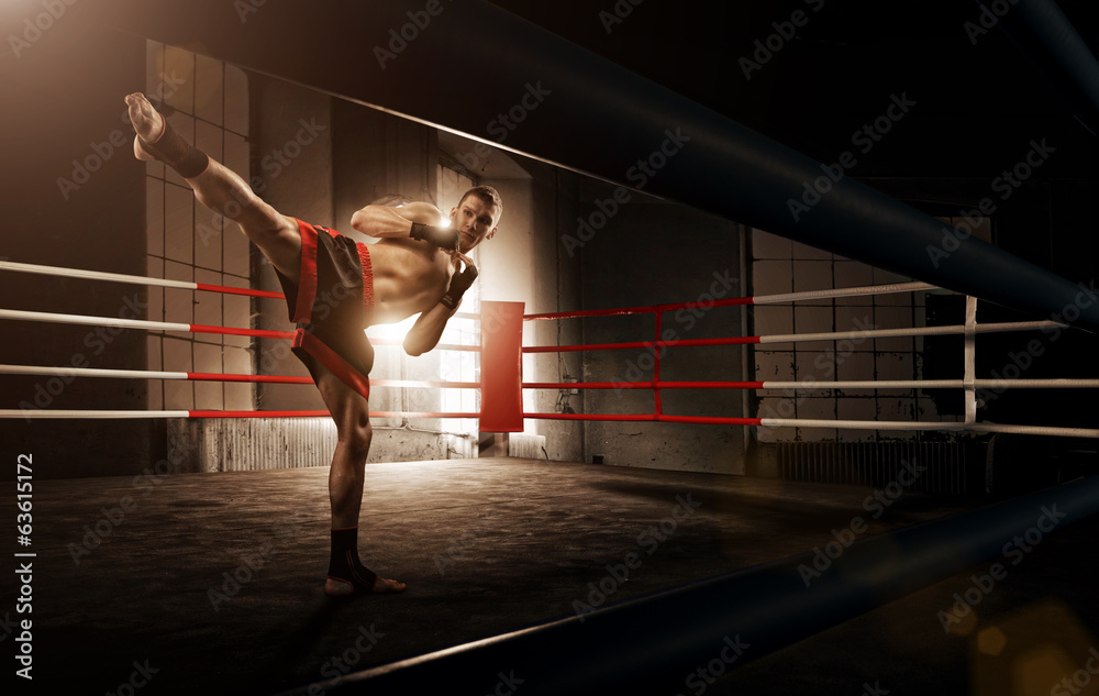 Fototapeta Young  man kickboxing in the