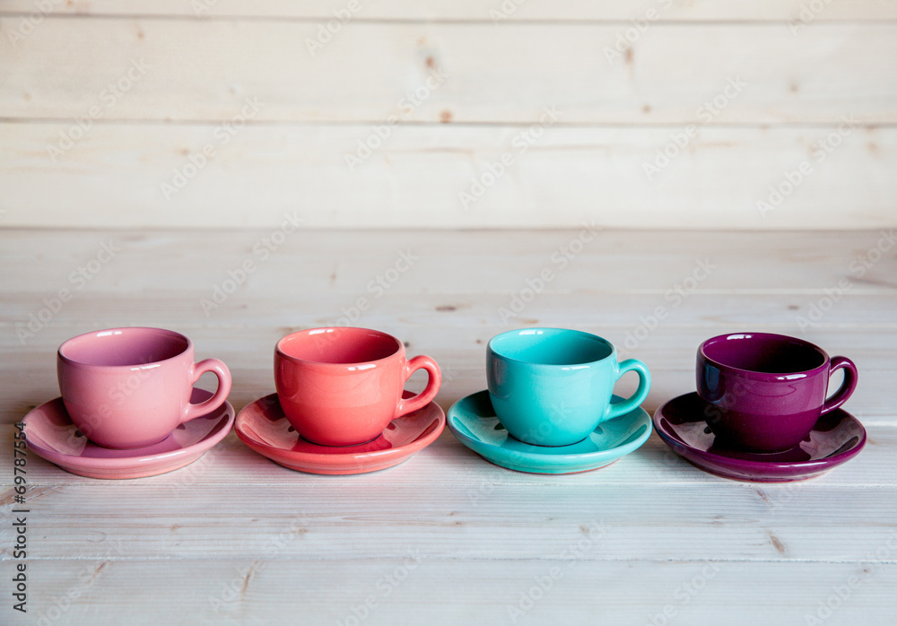 Fototapeta Colorful coffee cups on wooden